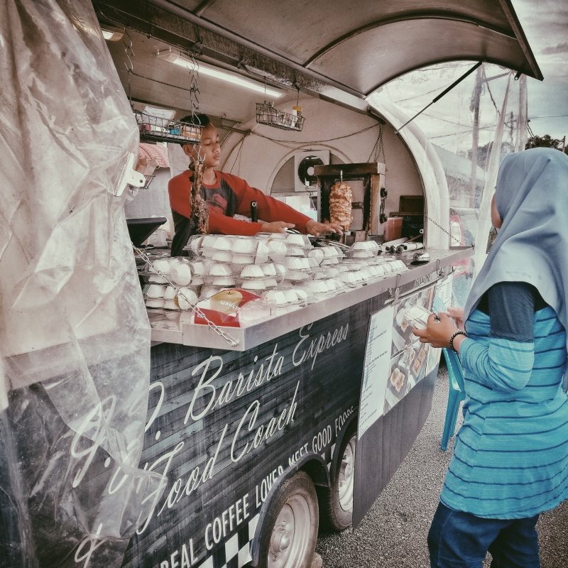 A person working at a food stand, photo using the Distinctive and blue P5 filter